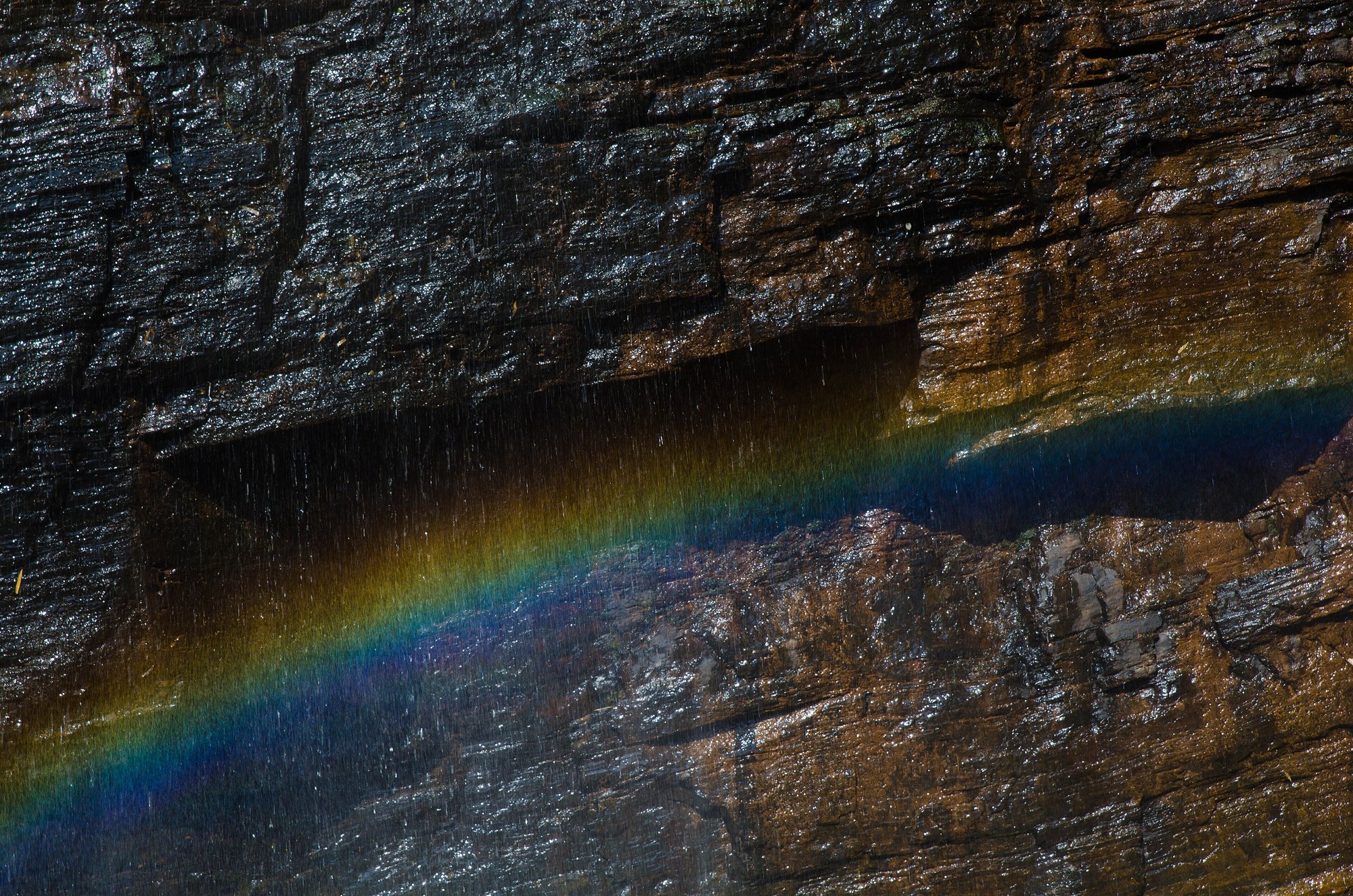 Rainbow across the rock face at Hebbe Falls near Kemmangundi