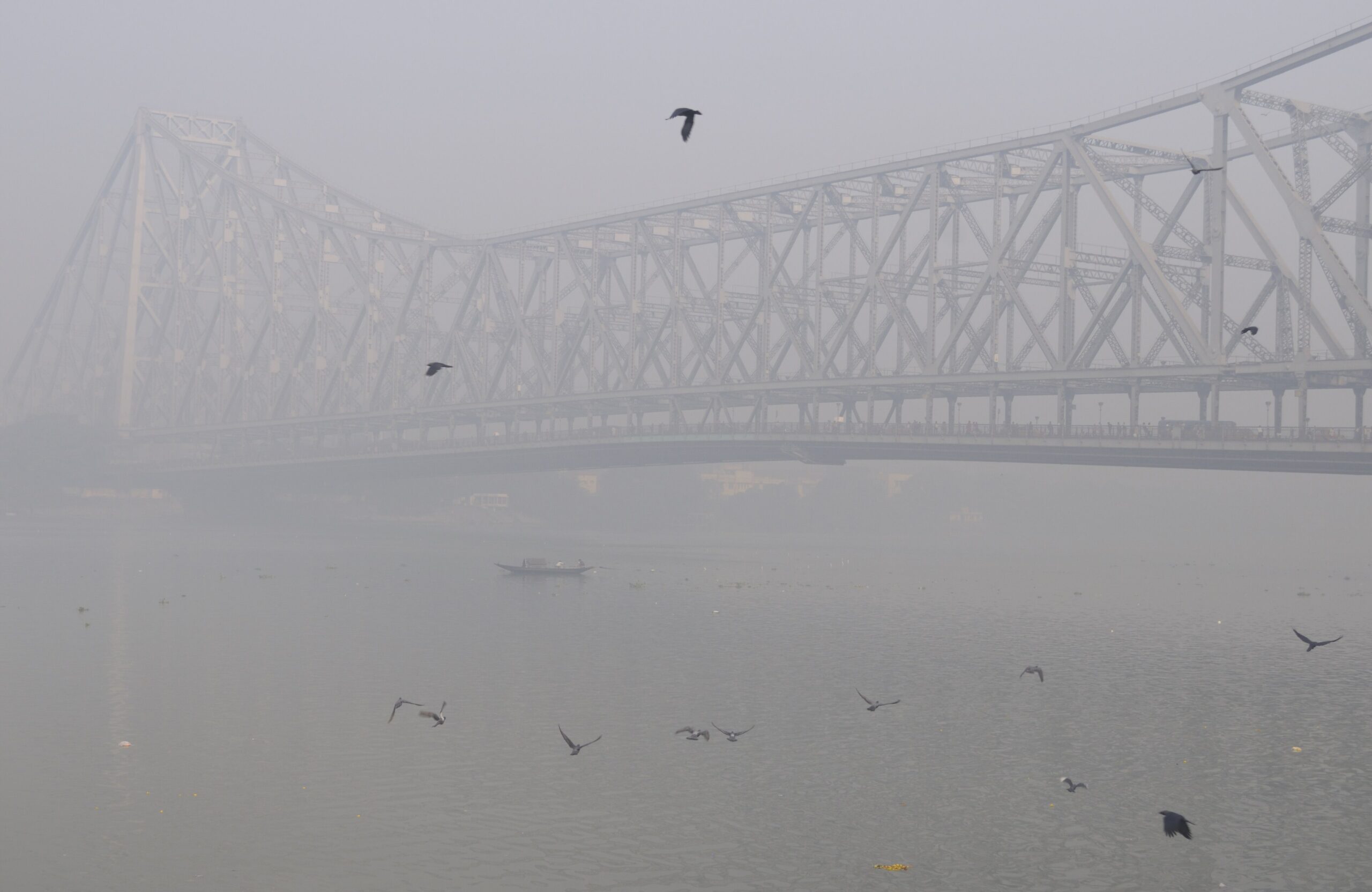 Howrah Bridge's steel cantilever span over the Hooghly river on a foggy morning in Kolkata