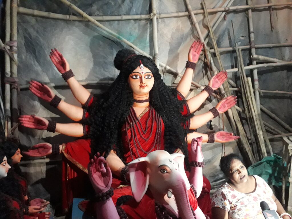 An artisan shaping a clay Durga idol in a Kumartuli workshop