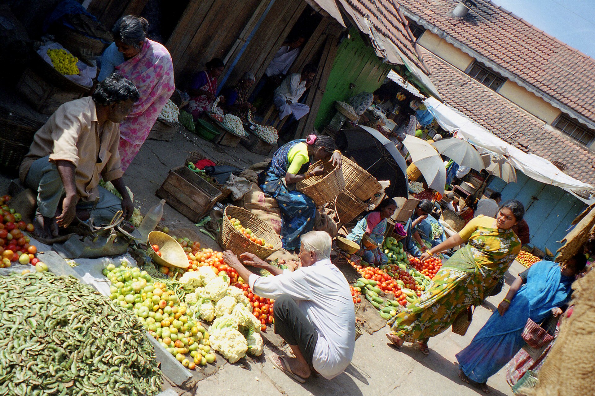 Vegetable and fruit sellers with baskets of produce in Mysuru's Devaraja Market