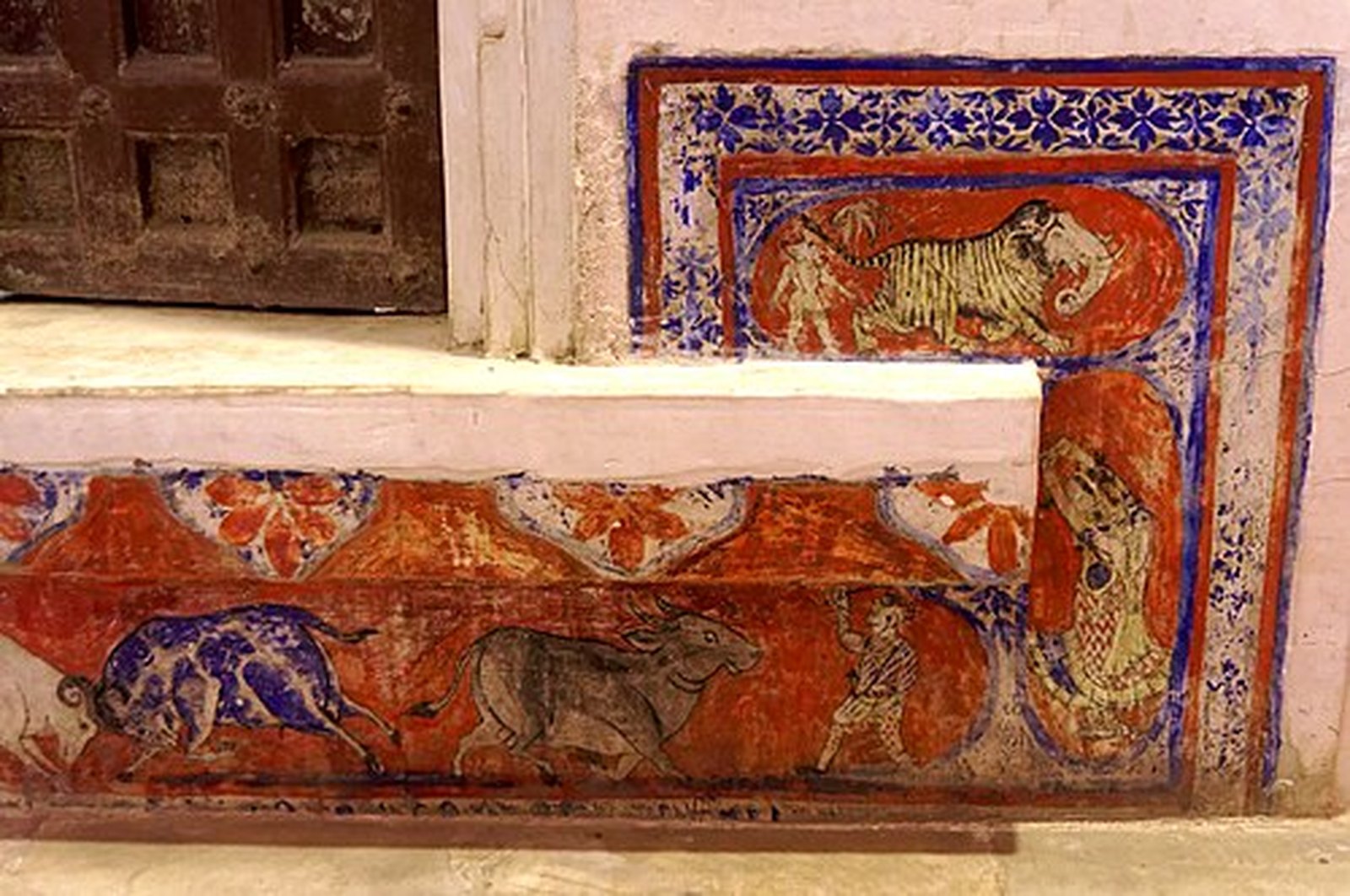 Painted fresco and stone steps inside a centuries-old Udaipur haveli