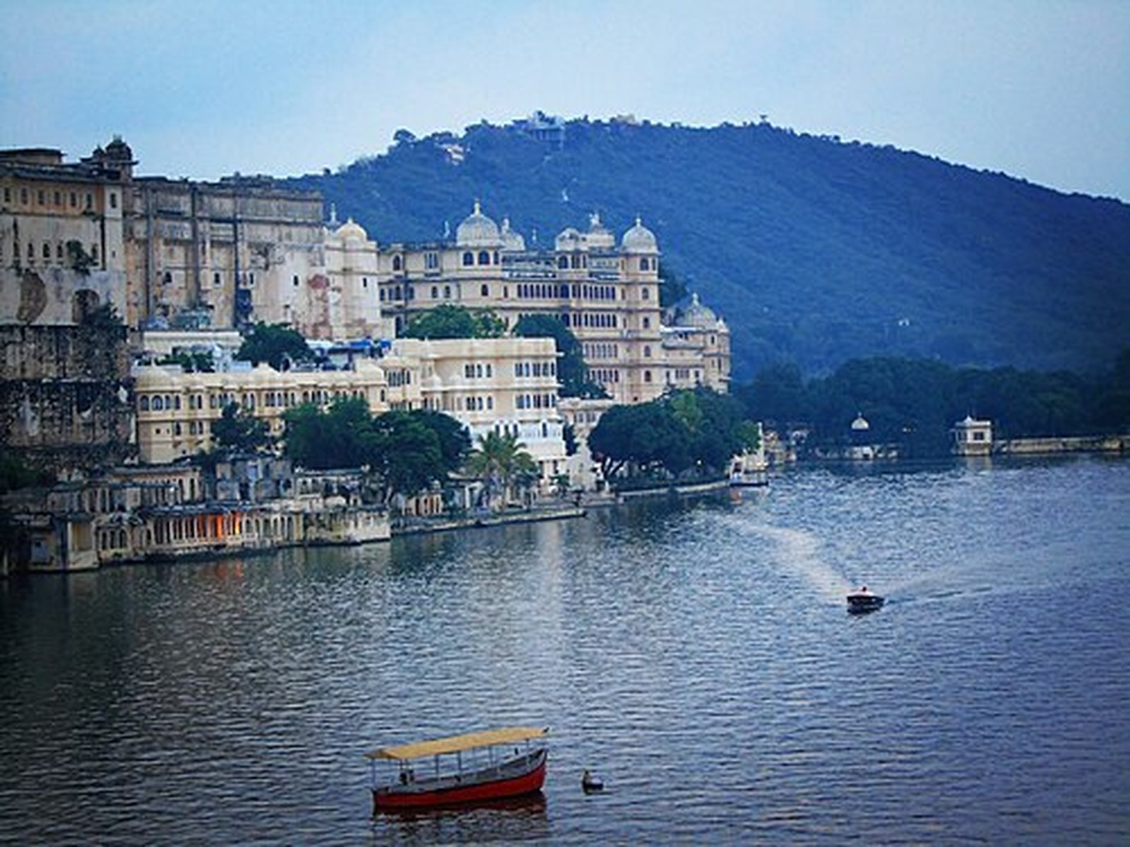 City Palace and Lake Pichola seen from the Ambrai Ghat side with a boat on the water