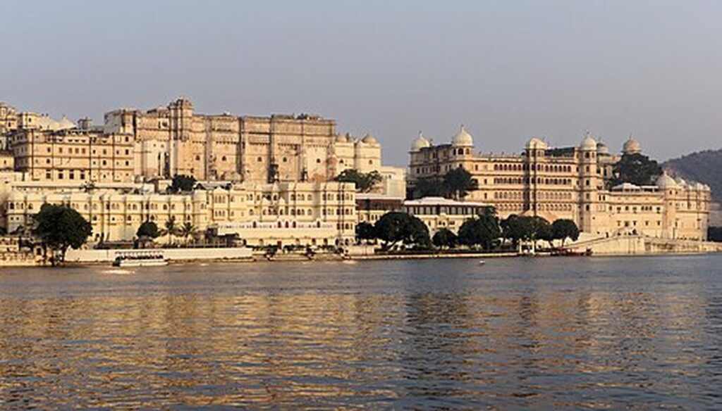 City Palace Udaipur glowing in golden light above Lake Pichola
