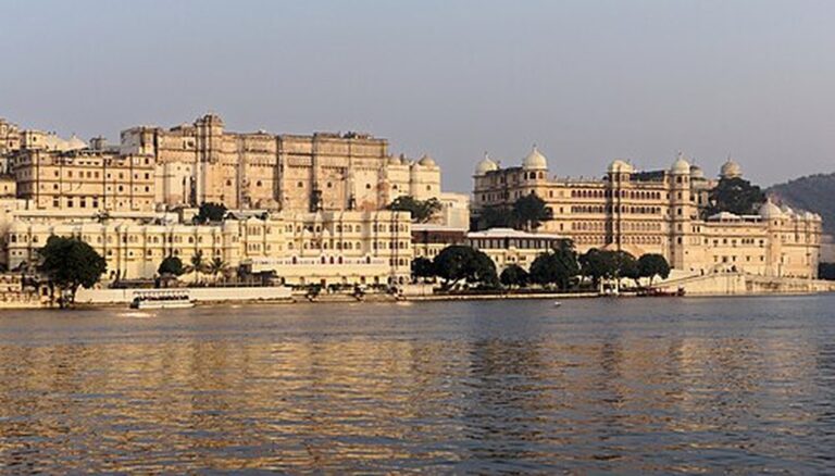 City Palace Udaipur glowing in golden light above Lake Pichola