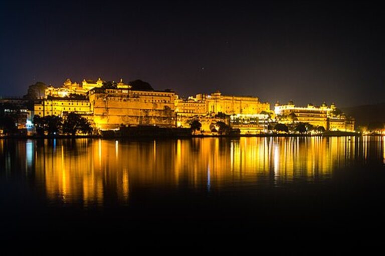 City Palace Udaipur illuminated at night and reflected in Lake Pichola