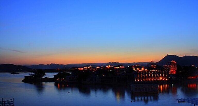 Blue-hour sunset over Lake Pichola with the illuminated palaces of Udaipur