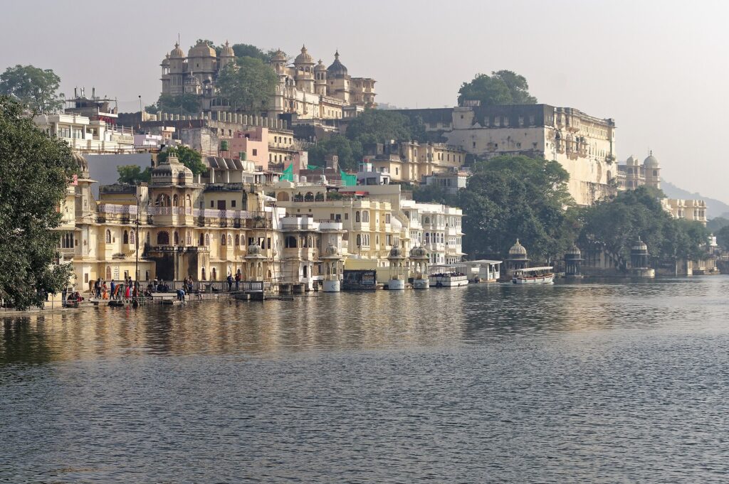 Morning light on the City Palace and old city buildings rising above Lake Pichola in Udaipur
