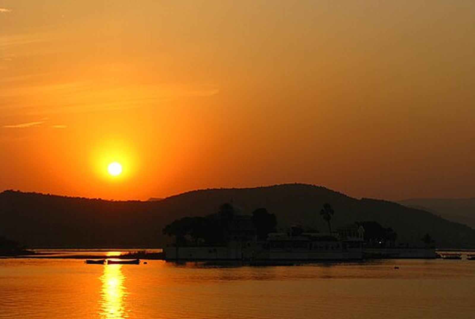Golden sun sinking over Lake Pichola and the Aravalli hills