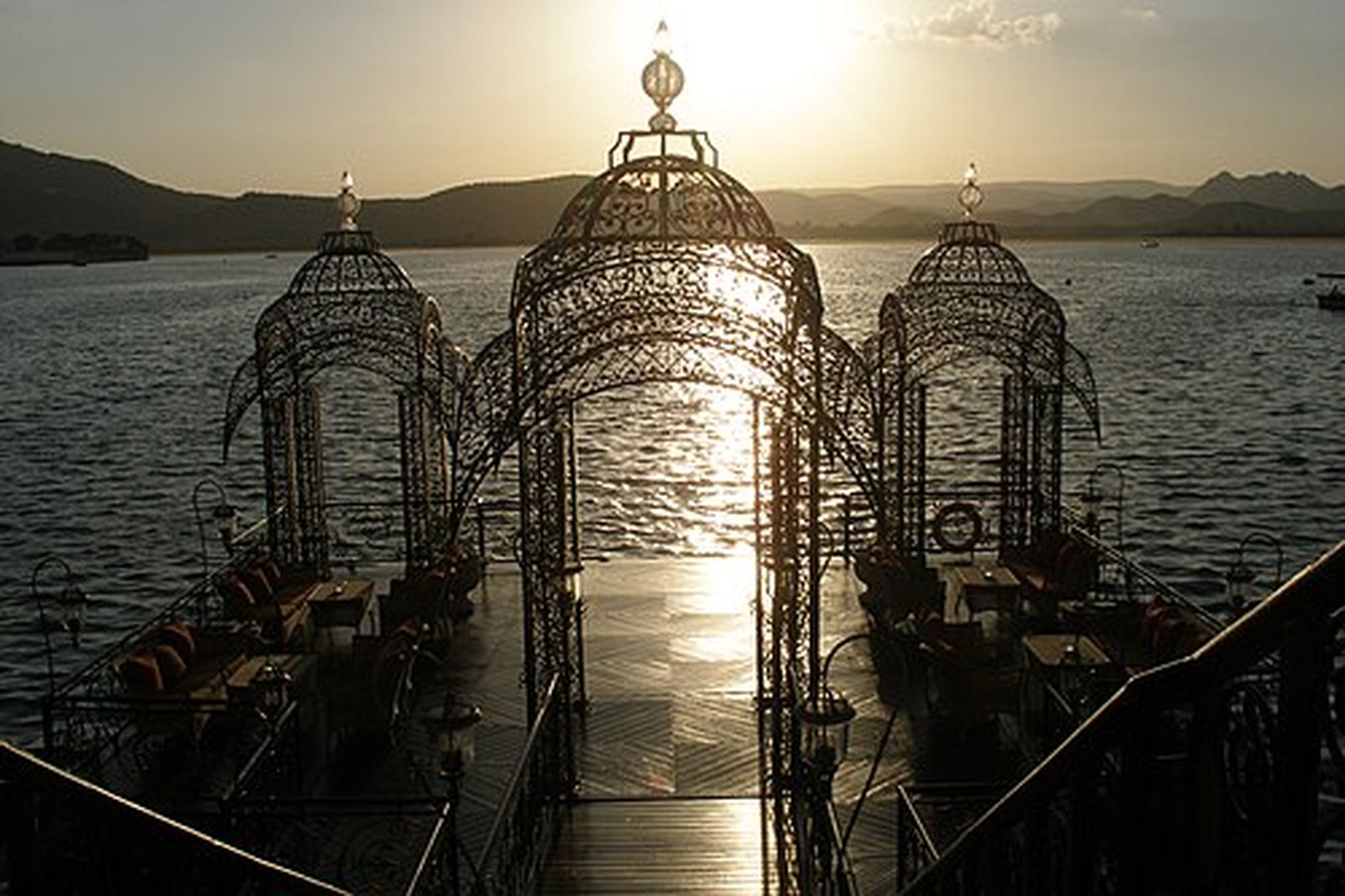 Sun setting over Lake Pichola behind a wrought-iron pavilion, Udaipur