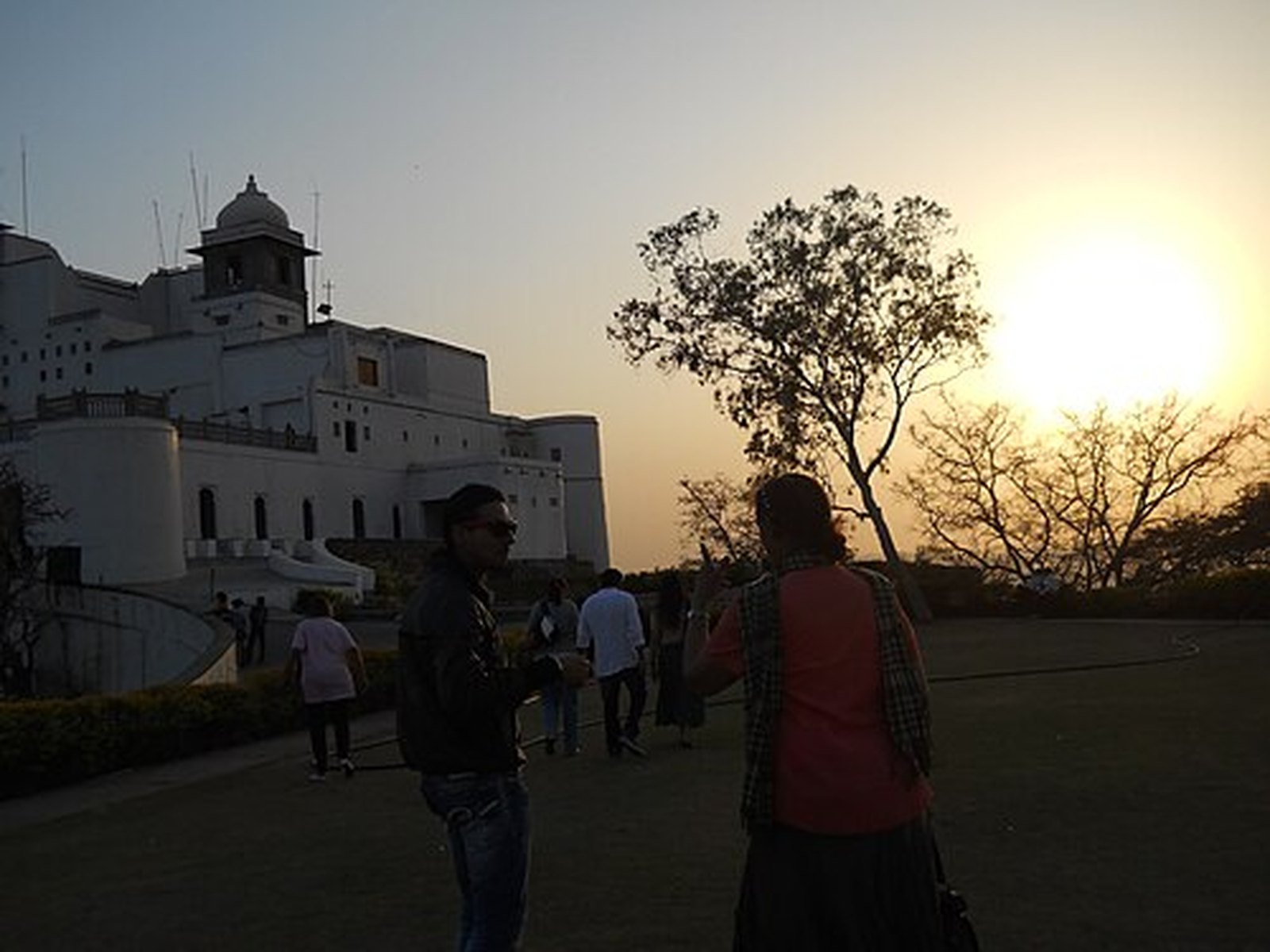Golden-hour sun behind Sajjangarh Monsoon Palace, Udaipur
